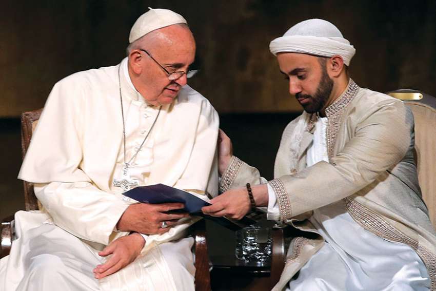 Pope Francis accepts a program from Iman Khalid Latif during an interreligious gathering in New York in 2015.