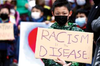 A boy in Seattle holds a sign during a “Kids vs. Racism” rally in March 2021.