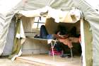 A refugee rests in a tent set up by the Canadian Armed Forces near the U.S.-Canadian border in Lacolle, Que.
