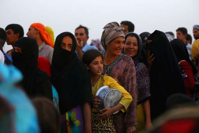Displaced Iraqi refugees line up to receive free food inside the Khazer camp on the outskirts of Irbil, Iraq, June 29. The number of displaced people because of their religious beliefs skyrocketed in 2013.