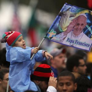A child waves a flag with an image of Pope Francis while waiting for his arrival on Copacabana beach during the World Youth Day welcoming ceremony in Rio de Janeiro July 25.