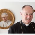 Bishop Bernard Fellay, superior of the Society of St. Pius X, is pictured near an image of St. Pius X at the society&#039;s headquarters in Menzingen, Switzerland, May 11. 