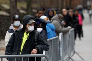 People at the Brooklyn Hospital Center in Brooklyn, N.Y., form a queue to enter a tent erected to test for coronavirus March 19, 2020.