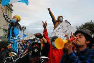Demonstrators shout slogans during a protest to demand the resignation of President Alejandro Giammattei in Guatemala City Nov. 22, 2020.