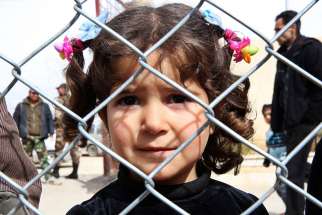 A displaced Syrian girl finds temporary shelter at a school in Damascus, Syria, Feb. 23.