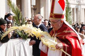 Pope Francis carries palm fronds in procession at the start of Palm Sunday Mass in St. Peter&#039;s Square at the Vatican March 25.