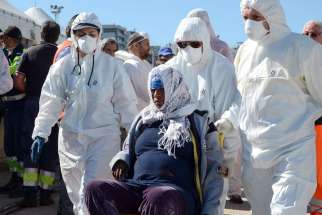 A migrant is assisted after arriving in Reggio Calabria, Italy, May 4. The Italian Coast Guard said at least 10 migrants died off Libya as they tried to cross the Mediterranean. Bishops across Europe have called for wider acceptance of migrants fleeing w ar and poverty in the Middle East and Africa. 
