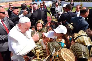 Pope Francis greets children dressed as pharaohs and in traditional dress as he arrives to celebrate Mass at the Air Defense Stadium in Cairo April 29.