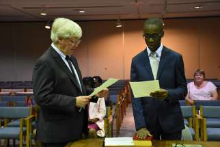 Joel Ndongmi is sworn in by Paul Matthews, General Legal Counsel for TCDSB, at the Catholic Education Centre on Sept. 7. 