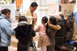 Filipinos receive Communion during the Simbang Gabi Mass at Holy Rosary Cathedral in Vancouver, British Columbia, Dec. 15.
