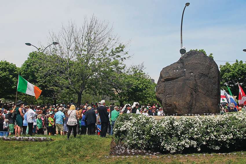 Crowds gather around the black stone on May 28 that marks the memorial to the 6,000 Irish refugees who died after arriving in Canada in 1947.