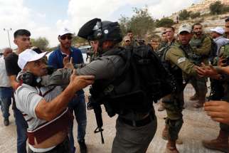 An Israeli border policeman scuffles with a Palestinian man during a protest near Ramallah, West Bank.