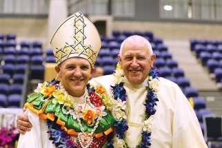 Auxiliary Bishop Michael Gielen of Auckland, New Zealand, poses with his father, Deacon Henk Gielen, after his episcopal ordination Mass March 7.