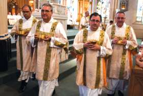 Deacons prepare to distribute communion at Mass.