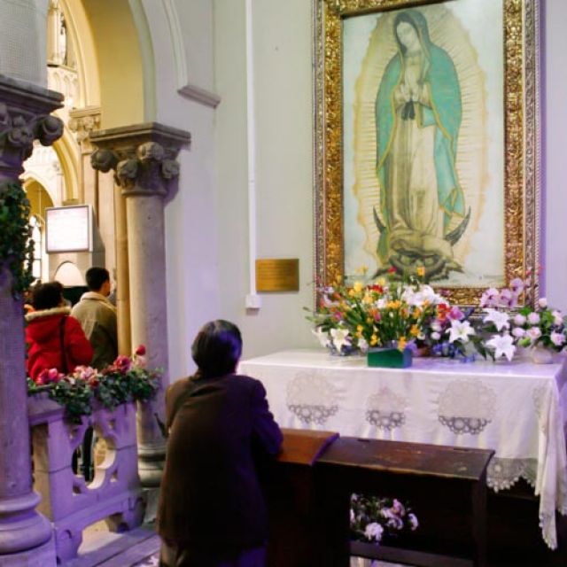 A Mass-goer prays in the Guadalupe chapel inside St. Ignatius Cathedral in Shanghai in this 2007 file photo. The image of Our Lady of Guadalupe -- most popular in Mexico and the Americas -- has been well-received by Catholics around the globe.