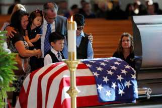 Billy Smith, brother of slain Dallas Police Sgt. Michael Smith, and his family grieve at the officer&#039;s casket during a July 12 visitation for him at Mary Immaculate Catholic Church in Farmers Branch, Texas. Smith, a member of the parish, was one of five officers killed when a gunman opened fire at a July 7 protest in downtown Dallas.