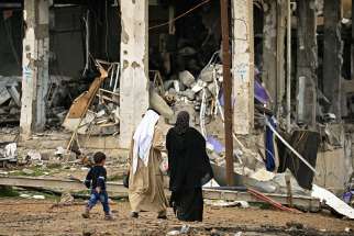 A displaced Iraqi family walks near destroyed buildings March 4 in the Mosul. Iraq was the largest recipient of Aid to the Church in Need&#039;s funds in 2016.