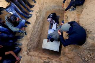 The body of Samer Fouad al-Talalka, a member of Israel&#039;s Bedouin Arab minority taken hostage by Hamas who was mistakenly killed by the Israeli military, is laid in the grave during his funeral in Hura village in southern Israel Dec 16, 2023. Al-Talalka was one of three Hamas hostages mistakenly killed by IDF troops in Gaza Dec. 15.