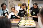 A group of four young chef students work together to prepare and plate side dishes during the Get Fed Up 2023 event. 