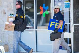 FBI agents are seen carrying items out in paper bags and boxes March 20 from a FedEx store in Austin, Texas, after a fifth bombing. &quot;These appalling attacks have killed and injured innocent people, young adults, and children who were in their homes, bicycling on the street, and working at their jobs,&quot; Archbishop Gustavo Garcia-Siller of San Antonio and Bishop Joe S. Vasquez of Austin said in a March 20 statement. 