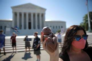 A pro-life activist holds a replica of a fetus outside the U.S. Supreme Court in Washington June 29, 2020.