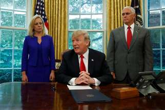 President Donald Trump is seen with with Secretary of Homeland Security Kirstjen Nielsen and Vice President Mike Pence at the White House June 20 prior to signing an executive order to halt the separation of families.
