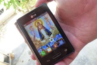 A cellphone screen displays an image of Our Lady of Charity of El Cobre, patroness of Cuba, in early March. Using memory cards on cellphones, a small number of Catholic Cubans have access to texts, such as the Bible or the Liturgy of the Hours, to help them maintain a life of prayer throughout the day.