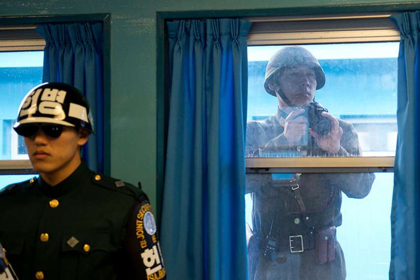 A North Korean soldier takes photos through the window of one of the conference rooms in the Joint Security Area between North and South Korean in 2012. 