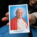 A Polish woman holds a prayer card featuring Blessed John Paul II during a Mass celebrated in his hometown of Wadowice, Poland, May 1, 2011, the day of his beatification. The late pontiff will be declared a saint, the Vatican said July 5, after officials approved a second miracle attributed to his intercession.