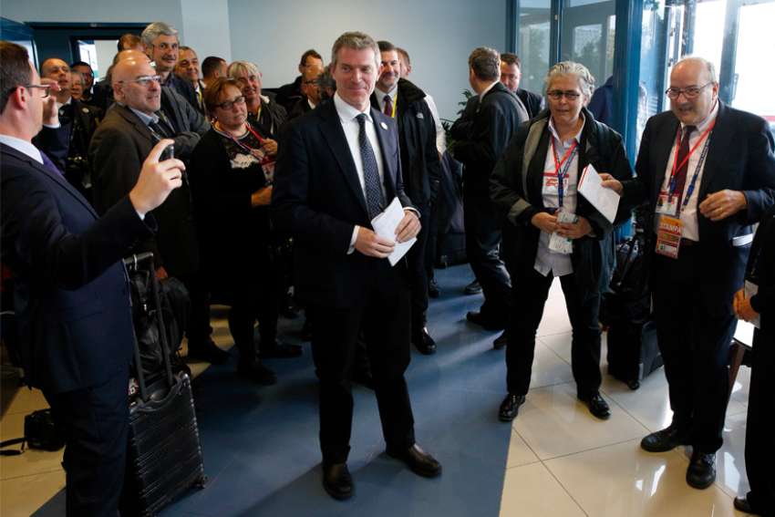 Matteo Bruni of the Vatican Press Office, center, listens as journalists honor him with a special song at the airport during Pope Francis&#039; visit in Sofia, Bulgaria, May 7, 2019. Bruni, who has helped organize and coordinate media presence on papal trips since 2013, has been appointed the new director of the Vatican Press Office.