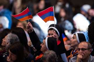 Women religious wave the Armenian flag in St. Peter&#039;s Basilica at the Vatican in this April 12, 2015, file photo. The Vatican is studying the possibility of Pope Francis visiting Armenia in late June, the Vatican spokesman said. 