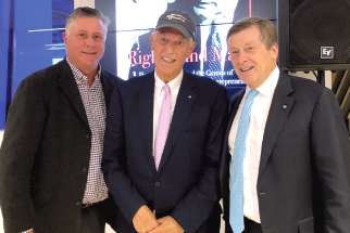 Phil Lind, centre, poses with Robert Brehl, left, and Toronto Mayor John Tory at the launch for Right Hand Man. Along with his political career, Tory was an executive at Rogers Communications. 