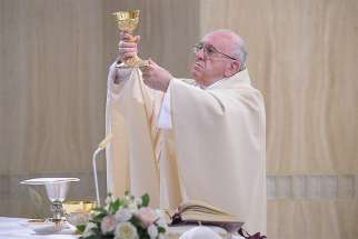 Pope Francis elevates the chalice as he celebrates Mass in the chapel of the Domus Sanctae Marthae at the Vatican April 26. 