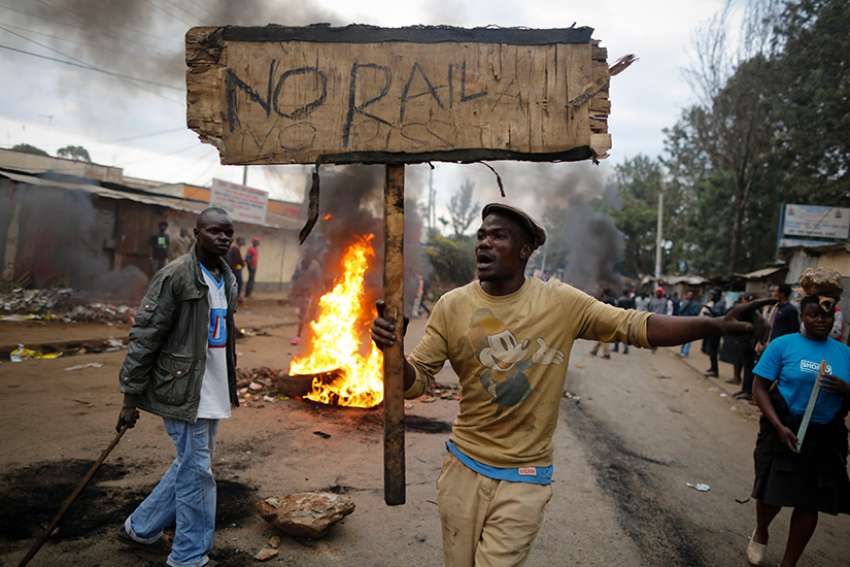 A supporter of the opposition leader Raila Odinga reacts as he holds up a sign that reads &quot;No Raila, No Peace&quot; during an Aug. 9 protest in Nairobi, Kenya. Catholic bishops in Kenya called for calm in the East Africa nation, as pockets of violent post election protests left at least five dead in opposition strongholds.