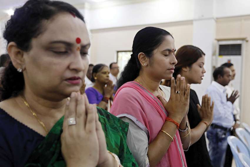 Hindu women pray for peace Oct. 1 at the Sri Bunar Maha Shiva Hindu temple in Yangon, Myanmar. Peace and harmony will not result from members of different religions simply tolerating each other; respect and appreciation of customs and cultural diversity is required, top Vatican officials said in a message to the world&#039;s Hindus. 