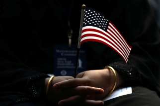 An immigrant holds a U.S. flag during a naturalization ceremony in New York City June 30.