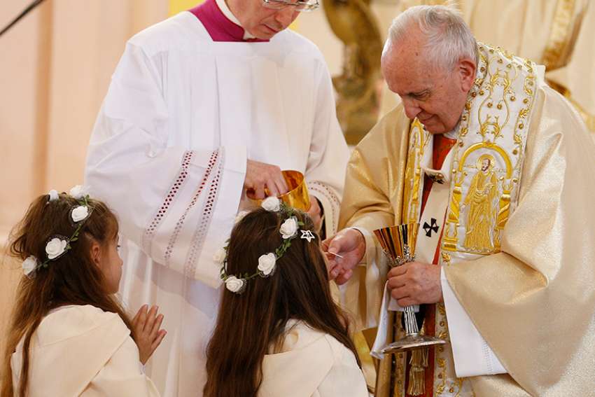 Pope Francis gives first Communion to children during a Mass at the Church of the Sacred Heart in Rakovski, Bulgaria, May 6, 2019. 