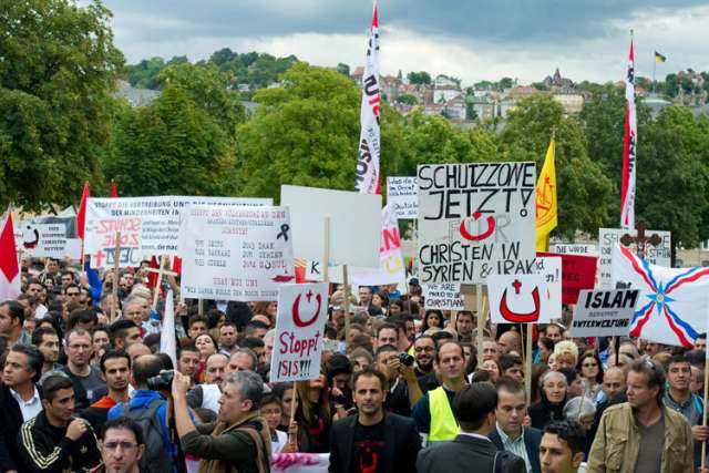 Protesters in Stuttgart, Germany, rally during an Aug. 23 demonstration initiated by the Syrian Orthodox Church in solidarity with religious minorities threatened in Northern Iraq and throughout the Middle East. The Franciscan custos of the Holy Land sai d force alone cannot stop &quot;religious cleansing&quot; in the Middle East.
