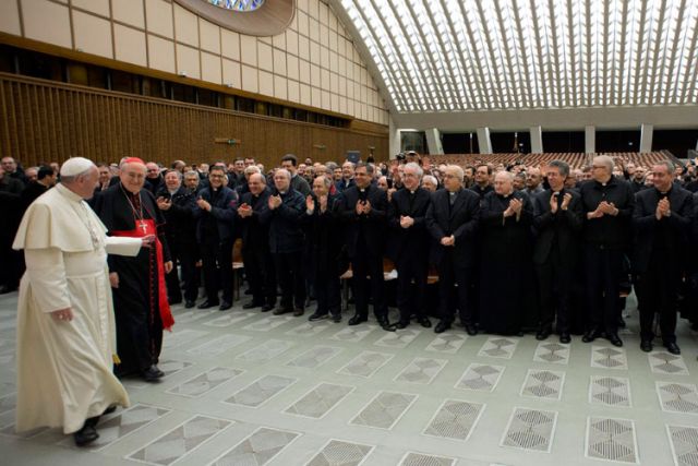 Pope Francis acknowledges applause from priests as he arrives for a meeting in the Paul VI audience hall at the Vatican March 6. The pope&#039;s annual Lenten meeting with Rome pastors focused on the priest&#039;s call to be a minister of mercy.
