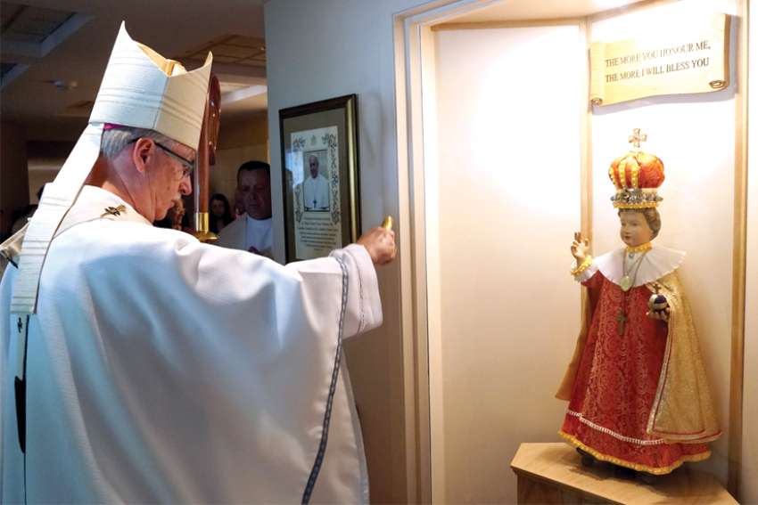 Edmonton Archbishop Richard Smith blesses the 500-year-old statue donated to the Discalced Carmelites.