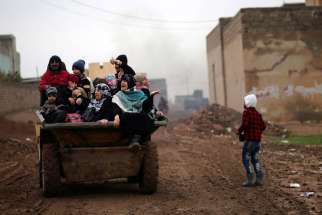 Displaced Iraqis ride in a truck Dec. 1 as they flee the Islamic State stronghold of Mosul.