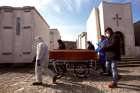 Funeral service workers transport a coffin of a victim of COVID-19 in Cisternino, Italy.