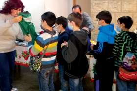 Children from the Maronite Archdiocese of Antelias, Lebanon, “shop” for a new outfit at a Christmas Village. The Dec. 8-10 event also featured a spirited children’s entertainment show, food to eat and a take-home snack.