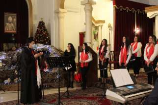 Syriac Catholic Patriarch Ignace Joseph III Younan is pictured with the Holy Missionary Choir during a pre-Christmas celebration for Iraqi Syriac Catholic refugee families in Lebanon Dec. 12, 2020. The celebration was at Sts. Behnam and Sarah Church in Fanar, Lebanon.