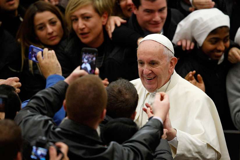 Pope Francis greets people as he leaves his general audience in Paul VI hall at the Vatican Jan. 13. 