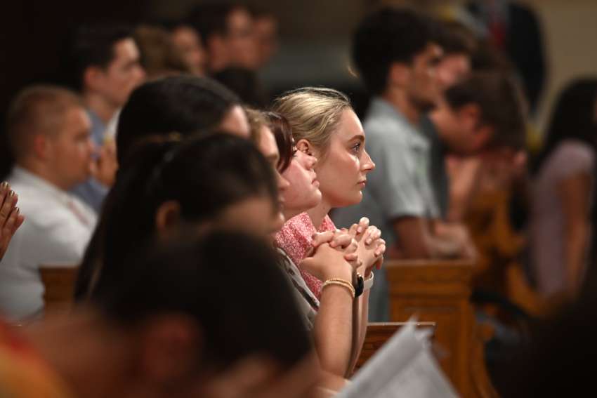 Students pray at the opening of the school year at Catholic University of America. Faith must remain a part of Catholic education, educators said at a recent discussion on a Vatican document on the identity of Catholic schools.