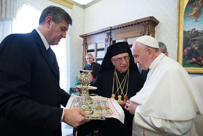 Pope Francis accepts gifts from Melkite Patriarch Joseph Absi during a meeting with the Melkite synod of bishops at the Vatican Feb. 12. The Melkite Church is an Eastern Catholic church in full communion with Rome. 