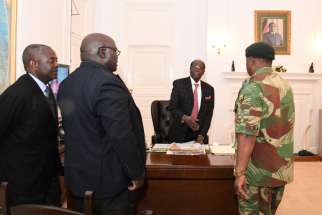 President Robert Mugabe, center, meets with Gen. Constantino Chiwenga, right, Nov. 19 at the State House in Harare. Looking on is Brigadier Gen. Happyton Bonyongwe, minister of justice, and Father Fidelis Mukonori, parliamentary liaison officer for Harare Archdiocese. 