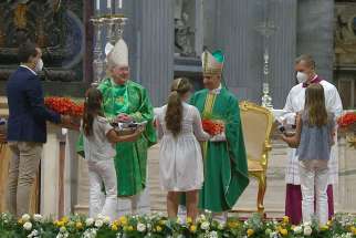 Cardinal Kevin J. Farrell, prefect of the Dicastery for Laity, the Family and Life, and Archbishop Rino Fisichella, president of the Pontifical Council for Promoting New Evangelization, bless baskets of flowers that young people distributed to older people attending Mass in St. Peter&#039;s Basilica at the Vatican July 25, 2021. The Mass marked the first World Day for Grandparents and the Elderly.