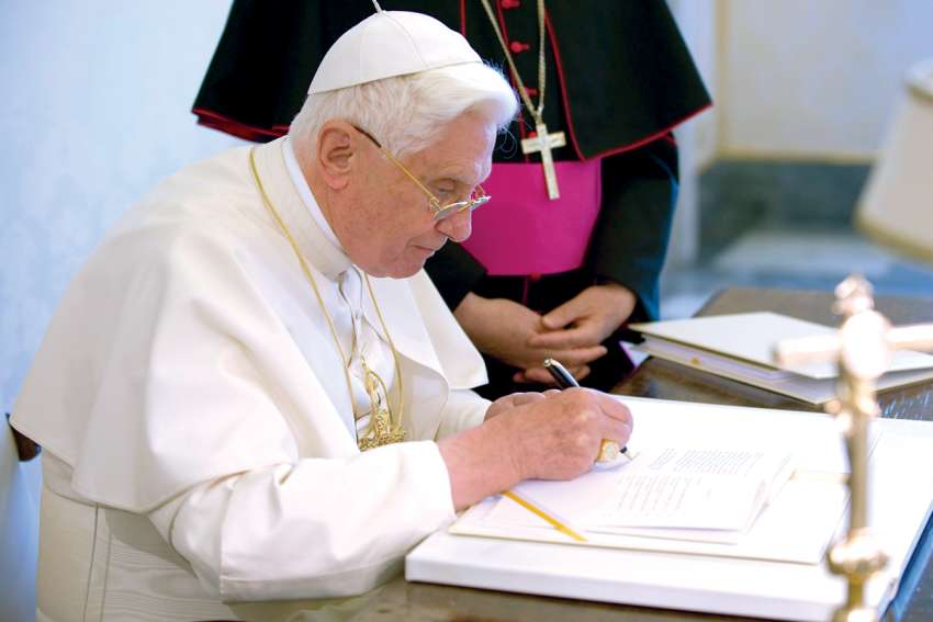 Pope Benedict XVI signs a copy of his encyclical, Caritas In Veritate (“Charity in Truth”), on July 6, 2009. 